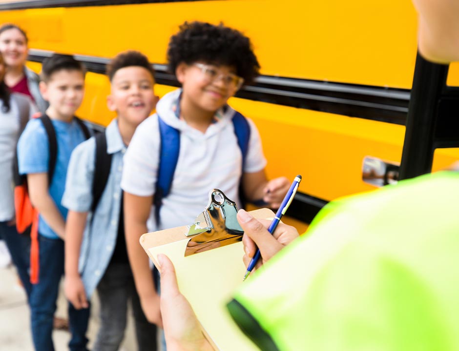 children lining up beside schoolbus